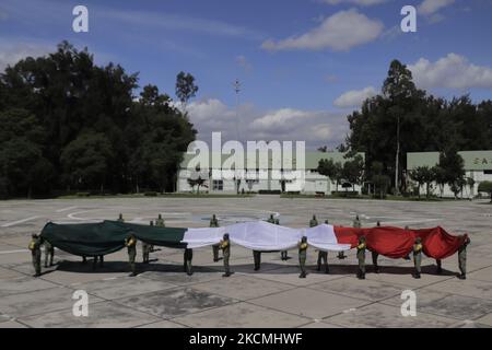 Membres du Secrétariat de la Défense nationale (SEDENA) sur l'esplanade de l'usine de vêtements et d'équipements El Vergel Iztapalapa, Mexico, Étaler un drapeau monumental dessiné et peint sur un tissu de nylon de haute qualité pour marquer le Grito de Independencia et la parade militaire qui se tiendra les 15 et 16 septembre pendant l'urgence sanitaire due à COVID-19 et le feu jaune de circulation épidémiologique dans la capitale. (Photo de Gerardo Vieyra/NurPhoto) Banque D'Images