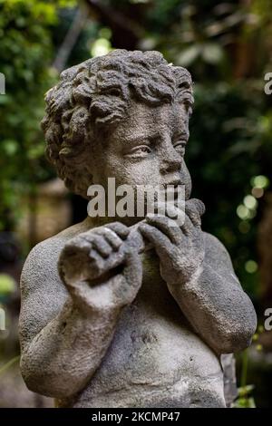Saint-Ouen, France, le 18 juillet 2021. Une statue d'un chérubin dans le jardin de la maison de François Casal qui sert également de magasin d'antiquités dans le marché Paul Bert. Banque D'Images