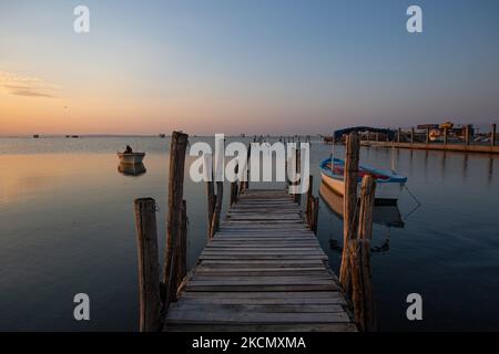 Petite jetée en bois pour les bateaux de pêche. Lever du soleil, l'aube et le soleil se reflétant sur la mer au Parc National du Delta d'Axios, un emplacement avec des zones humides près de Halastra et de la ville de Thessalonique où 4 fleuves Gallikos, Axios, Loudias et Aliakomnas ont leur delta. À l'endroit précis, les pêcheurs et les producteurs de moules ont leurs huttes et leurs bateaux. Au sujet de la biodiversité, cette région est célèbre et d'importance ornithologique mondiale, car des populations considérables d'oiseaux rares s'arrêtent, nichent ou hivernent ici, tandis que 299 espèces d'oiseaux ont été documentées. Comme sur flore et faune plus de 370 espèces de pl Banque D'Images