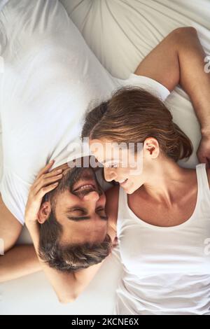 Je vous le suis. Photo en grand angle d'un jeune couple heureux qui se détend au lit ensemble à la maison. Banque D'Images