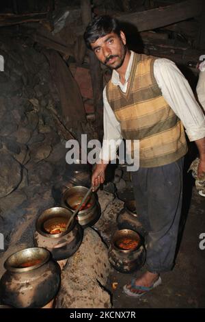 Un waza de Kashmiri (cuisinier expert) prépare un wazwan (banquet) de 54 plats de viande sur feu de bois dans une cuisine improvisée pour un mariage musulman à Pahalgam, Cachemire, Inde. (Photo de Creative Touch Imaging Ltd./NurPhoto) Banque D'Images