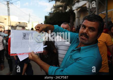 Des hommes palestiniens se réunissent pour demander des permis de travail en Israël, au camp de réfugiés de Jabalia, dans le nord de la bande de Gaza, sur 6 octobre 2021. (Photo de Majdi Fathi/NurPhoto) Banque D'Images