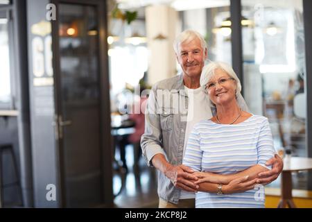 Notre endroit préféré à visiter. Portrait d'un heureux couple senior debout ensemble dans un café. Banque D'Images