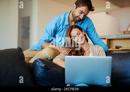 Un jeune couple affectueux qui se détend sur le canapé à la maison. Banque D'Images