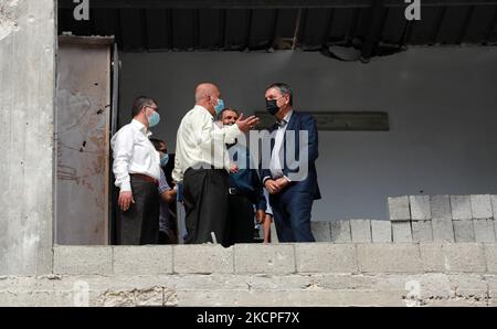 Office de secours et de travaux des Nations Unies pour les réfugiés de Palestine dans le proche-Orient (UNRWA) le Commissaire général Philippe Lazzarini (R) visite la maison de la famille Salmiya qui a été endommagée par les frappes israéliennes lors des combats entre Israël et le Hamas en mai dernier, dans le camp de réfugiés d'al-Shati à Gaza, sur 12 octobre 2021. (Photo de Majdi Fathi/NurPhoto) Banque D'Images