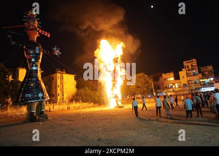 Les gens regardent comme des effigies du démon Roi Ravana, son fils Meghnad et frère Kumbhkarana sont brûlés pendant le festival hindou de Dussehra, au milieu de la propagation du coronavirus (COVID-19) à New Delhi, en Inde sur 15 octobre 2021. (Photo de Mayank Makhija/NurPhoto) Banque D'Images