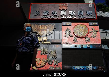 Un homme portant un masque de protection passe devant les panneaux publicitaires des discothèques sur 21 octobre 2021 à Singapour. (Photo de Suhaimi Abdullah/NurPhoto) Banque D'Images