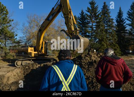 Des équipes d'excavation, observées par des membres des Premières nations, enquêtent sur l'un des 21 points d'intérêt sur le site de l'ancien hôpital Camsell. La deuxième phase des travaux d'excavation a commencé aujourd'hui sur le site de l'ancien hôpital Charles Camsell, l'établissement d'Edmonton qui a été utilisé pendant des décennies pour traiter les populations autochtones atteintes de tuberculose. Les membres des Premières nations ont demandé que les travaux de construction s'arrêtent sur les terrains où beaucoup croient que les patients ont pu être enterrés. La recherche est financée par le promoteur de la propriété. Le jeudi 21 octobre 2021, à Inglewood, Edmonton (Alberta), Canada. (Pho Banque D'Images