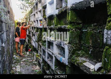 Les résidents de la ville d'Antipolo, Philippines, visitent le tombeau de leurs proches à l'intérieur des cimetières sur 27 octobre 2021. Depuis que la pandémie a frappé les Philippines le 2020 mars, des cimetières publics et privés dans le pays ferment encore leurs portes pour les visiteurs qui viennent à 29 octobre jusqu'à 2 novembre pour éviter la propagation massive de COVID-19 à la célébration de la Journée de l'âme. (Photo par Ryan Eduard Benaid/NurPhoto) Banque D'Images