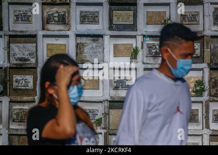 Les résidents de la ville d'Antipolo, Philippines, visitent le tombeau de leurs proches à l'intérieur des cimetières sur 27 octobre 2021. Depuis que la pandémie a frappé les Philippines le 2020 mars, des cimetières publics et privés dans le pays ferment encore leurs portes pour les visiteurs qui viennent à 29 octobre jusqu'à 2 novembre pour éviter la propagation massive de COVID-19 à la célébration de la Journée de l'âme. (Photo par Ryan Eduard Benaid/NurPhoto) Banque D'Images