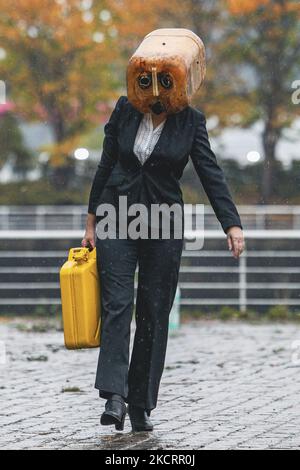 Les activistes de la rébellion océanique, vêtus d'Ouilheads, ont fait cracher une substance semblable à du pétrole sur la rive sud de la Clyde, en face du campus écossais sur 29 octobre 2021 à Glasgow, en Écosse. Ocean Rebellion un groupe d'activistes lié à la campagne de la rébellion de l'extinction pour mettre en évidence la dépendance des mondes aux combustibles fossiles par le biais de représentations théâtrales et de manifestations. La performance a eu lieu en face du Scottish Event Campus SEC, le site de la prochaine Conférence sur les changements climatiques de COP26, qui durera 12 jours et impliquera plus de 30 000 délégués. (Photo par Ewan Bootman/ Banque D'Images