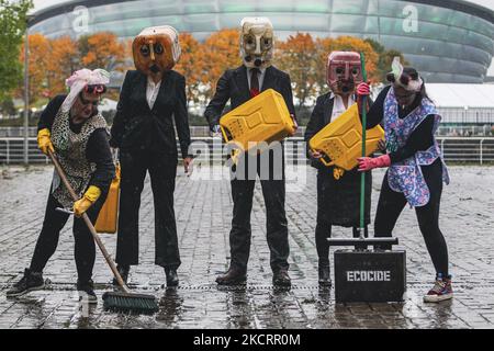 Les activistes de la rébellion océanique, vêtus d'Ouilheads, ont fait cracher une substance semblable à du pétrole sur la rive sud de la Clyde, en face du campus écossais sur 29 octobre 2021 à Glasgow, en Écosse. Ocean Rebellion un groupe d'activistes lié à la campagne de la rébellion de l'extinction pour mettre en évidence la dépendance des mondes aux combustibles fossiles par le biais de représentations théâtrales et de manifestations. La performance a eu lieu en face du Scottish Event Campus SEC, le site de la prochaine Conférence sur les changements climatiques de COP26, qui durera 12 jours et impliquera plus de 30 000 délégués. (Photo par Ewan Bootman/ Banque D'Images