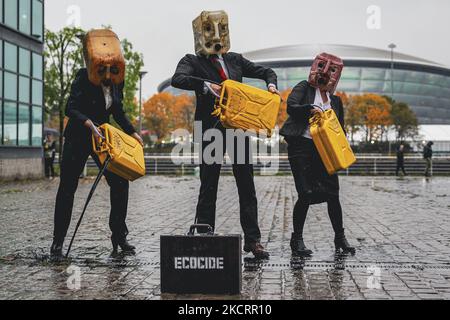 Les activistes de la rébellion océanique, vêtus d'Ouilheads, ont fait cracher une substance semblable à du pétrole sur la rive sud de la Clyde, en face du campus écossais sur 29 octobre 2021 à Glasgow, en Écosse. Ocean Rebellion un groupe d'activistes lié à la campagne de la rébellion de l'extinction pour mettre en évidence la dépendance des mondes aux combustibles fossiles par le biais de représentations théâtrales et de manifestations. La performance a eu lieu en face du Scottish Event Campus SEC, le site de la prochaine Conférence sur les changements climatiques de COP26, qui durera 12 jours et impliquera plus de 30 000 délégués. (Photo par Ewan Bootman/ Banque D'Images