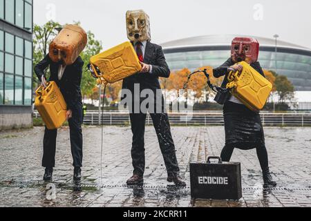 Les activistes de la rébellion océanique, vêtus d'Ouilheads, ont fait cracher une substance semblable à du pétrole sur la rive sud de la Clyde, en face du campus écossais sur 29 octobre 2021 à Glasgow, en Écosse. Ocean Rebellion un groupe d'activistes lié à la campagne de la rébellion de l'extinction pour mettre en évidence la dépendance des mondes aux combustibles fossiles par le biais de représentations théâtrales et de manifestations. La performance a eu lieu en face du Scottish Event Campus SEC, le site de la prochaine Conférence sur les changements climatiques de COP26, qui durera 12 jours et impliquera plus de 30 000 délégués. (Photo par Ewan Bootman/ Banque D'Images