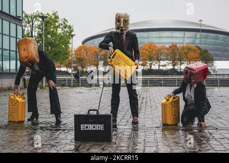 Les activistes de la rébellion océanique, vêtus d'Ouilheads, ont fait cracher une substance semblable à du pétrole sur la rive sud de la Clyde, en face du campus écossais sur 29 octobre 2021 à Glasgow, en Écosse. Ocean Rebellion un groupe d'activistes lié à la campagne de la rébellion de l'extinction pour mettre en évidence la dépendance des mondes aux combustibles fossiles par le biais de représentations théâtrales et de manifestations. La performance a eu lieu en face du Scottish Event Campus SEC, le site de la prochaine Conférence sur les changements climatiques de COP26, qui durera 12 jours et impliquera plus de 30 000 délégués. (Photo par Ewan Bootman/ Banque D'Images