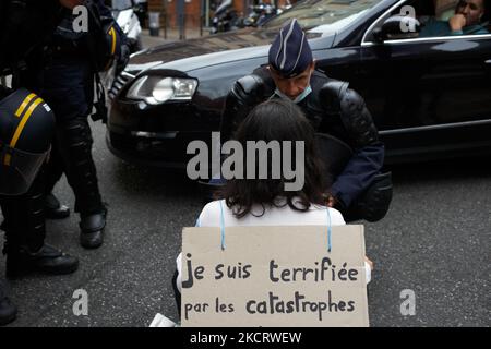 Un policier anti-émeute tente de convaincre une militante XR de quitter la route alors qu'elle la bloque. Son écriteau indique que « Je suis terrifiée par la catastrophe plus nombreux et plus meurtrière en raison du réchauffement climatique ». XR France (extinction rébellion France) a oraganisé dans plusieurs villes françaises un opérette de blocus routier réputé 'rébellion d'un'. Une personne s'assoit au milieu de la circulation, la bloque et s'y tient avec un écriteau expliquant les raisons du sit-in. Cette opératine est directement liée au COP26 qui commencera sur 31 octobre à Glasgow. Le GIEC peint une planète invivable si les émissions de gaz à effet de serre se cont Banque D'Images