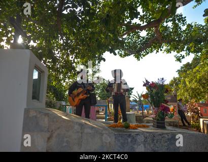 Les membres du groupe local de Los Compas exécutent une chanson traditionnelle mexicaine, le jour des morts (en espagnol: Día de Muertos) dans le cimetière municipal de Playa del Carmen. La Toussaint au Mexique coïncide avec le premier jour de la célébration du jour des morts (Día de Muertos). Il commémore les enfants qui sont morts (Dia de los Inocentes) et le deuxième jour célèbre tous les adultes décédés. En 2008, la tradition a été inscrite sur la liste représentative du patrimoine culturel immatériel de l'humanité par l'UNESCO. Le lundi 1 novembre 2021, à Playa Del Carmen, Quintana Roo, Mexique. (Photo par Artur W Banque D'Images