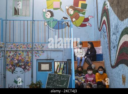 Des écoliers et des écolières réfugiés afghans sont-ils assis dans les escaliers de l'école de Farhang le premier jour de la nouvelle année scolaire? Dans le sud de Téhéran sur 1 novembre 2021. L'école de Farhang a fondé en 2000 par le réfugié afghan Nader Mousavi qui a obtenu une maîtrise en sociologie de l'Université de Téhéran, pour les enfants réfugiés afghans, Et maintenant deux ans après le début de l'épidémie de COVID-19 en Iran, où l'école fonctionnait à temps partiel, elle a commencé à fonctionner à temps plein et les écoliers et les écoliers afghans peuvent aller à l'école. Les familles n'ont pas à payer d'argent pour les frais de scolarité comme moi Banque D'Images