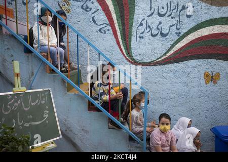 Les jeunes filles réfugiées afghanes s'assoient dans les escaliers à l'école de Farhang le premier jour de la nouvelle année scolaire ? Dans le sud de Téhéran sur 1 novembre 2021. L'école de Farhang a fondé en 2000 par le réfugié afghan Nader Mousavi qui a obtenu une maîtrise en sociologie de l'Université de Téhéran, pour les enfants réfugiés afghans, Et maintenant deux ans après le début de l'épidémie de COVID-19 en Iran, où l'école fonctionnait à temps partiel, elle a commencé à fonctionner à temps plein et les écoliers et les écoliers afghans peuvent aller à l'école. Les familles n'ont pas à payer l'argent pour les frais de scolarité car il est gratuit pour Un Banque D'Images