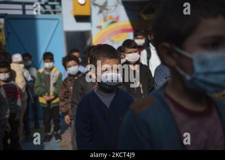 Des écoliers réfugiés afghans portant des masques protecteurs se tiennent à l'école de Farhang le premier jour de la nouvelle année scolaire? Dans le sud de Téhéran sur 1 novembre 2021. L'école de Farhang a fondé en 2000 par le réfugié afghan Nader Mousavi qui a obtenu une maîtrise en sociologie de l'Université de Téhéran, pour les enfants réfugiés afghans, Et maintenant deux ans après le début de l'épidémie de COVID-19 en Iran, où l'école fonctionnait à temps partiel, elle a commencé à fonctionner à temps plein et les écoliers et les écoliers afghans peuvent aller à l'école. Les familles n'ont pas à payer l'argent pour le tuitio Banque D'Images