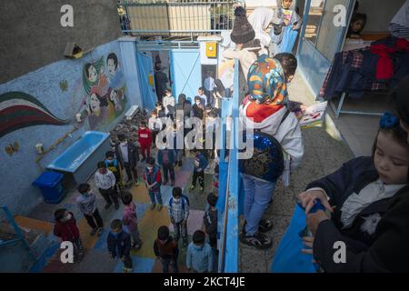 Les élèves réfugiés afghans font la queue en attendant les livres scolaires reçus à l'école de Farhang le premier jour de la nouvelle année scolaire? Dans le sud de Téhéran sur 1 novembre 2021. L'école de Farhang a fondé en 2000 par le réfugié afghan Nader Mousavi qui a obtenu une maîtrise en sociologie de l'Université de Téhéran, pour les enfants réfugiés afghans, Et maintenant deux ans après le début de l'épidémie de COVID-19 en Iran, où l'école fonctionnait à temps partiel, elle a commencé à fonctionner à temps plein et les écoliers et les écoliers afghans peuvent aller à l'école. Les familles n'ont pas à payer d'argent pour t Banque D'Images