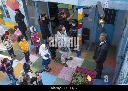 Le fondateur et directeur de l'école afghane Farhang, Nader Mousavi (R), bat la cloche de l'école le premier jour de la nouvelle année scolaire? Dans le sud de Téhéran sur 1 novembre 2021. L'école de Farhang a fondé en 2000 par le réfugié afghan Nader Mousavi qui a obtenu une maîtrise en sociologie de l'Université de Téhéran, pour les enfants réfugiés afghans, Et maintenant deux ans après le début de l'épidémie de COVID-19 en Iran, où l'école fonctionnait à temps partiel, elle a commencé à fonctionner à temps plein et les écoliers et les écoliers afghans peuvent aller à l'école. Les familles n'ont pas à payer le mone Banque D'Images