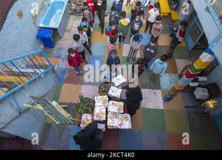 Les élèves réfugiés afghans font la queue en attendant les livres scolaires reçus à l'école de Farhang le premier jour de la nouvelle année scolaire? Dans le sud de Téhéran sur 1 novembre 2021. L'école de Farhang a fondé en 2000 par le réfugié afghan Nader Mousavi qui a obtenu une maîtrise en sociologie de l'Université de Téhéran, pour les enfants réfugiés afghans, Et maintenant deux ans après le début de l'épidémie de COVID-19 en Iran, où l'école fonctionnait à temps partiel, elle a commencé à fonctionner à temps plein et les écoliers et les écoliers afghans peuvent aller à l'école. Les familles n'ont pas à payer d'argent pour t Banque D'Images