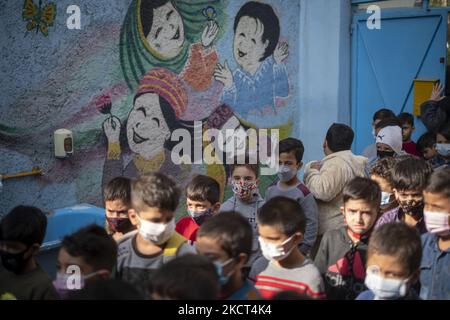 Les élèves réfugiés afghans font la queue à l'école de Farhang le premier jour de la nouvelle année scolaire? Dans le sud de Téhéran sur 1 novembre 2021. L'école de Farhang a fondé en 2000 par le réfugié afghan Nader Mousavi qui a obtenu une maîtrise en sociologie de l'Université de Téhéran, pour les enfants réfugiés afghans, Et maintenant deux ans après le début de l'épidémie de COVID-19 en Iran, où l'école fonctionnait à temps partiel, elle a commencé à fonctionner à temps plein et les écoliers et les écoliers afghans peuvent aller à l'école. Les familles n'ont pas à payer d'argent pour les frais de scolarité car il est gratuit pour les Afghans Banque D'Images