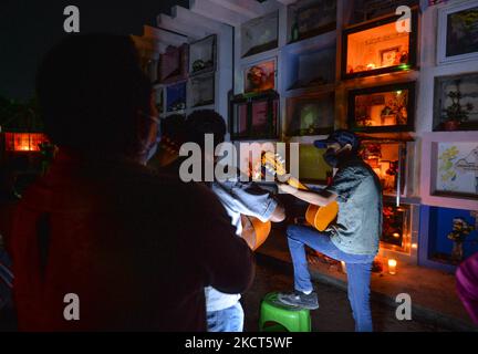 Chanson mexicaine traditionnelle interprétée par un groupe local, le jour des morts (en espagnol: Día de Muertos) dans le cimetière municipal de Playa del Carmen. La Toussaint au Mexique coïncide avec le premier jour de la célébration du jour des morts (Día de Muertos). Il commémore les enfants qui sont morts (Dia de los Inocentes) et le deuxième jour célèbre tous les adultes décédés. En 2008, la tradition a été inscrite sur la liste représentative du patrimoine culturel immatériel de l'humanité par l'UNESCO. Le mardi 2 novembre 2021, à Playa Del Carmen, Quintana Roo, Mexique. (Photo par Artur Widak/NurPhoto) Banque D'Images