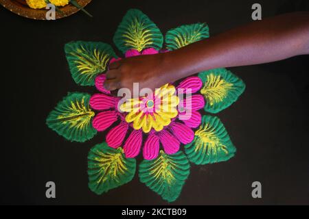 Une femme hindoue crée un motif ranglo coloré à l'aide de poudre colorée pendant le festival de Diwali à un temple hindou à Toronto, Ontario, Canada, on 04 novembre 2021. Le rangoli est un dessin traditionnel dessiné sur le sol avec de la poudre colorée, souvent devant les maisons ou les temples. (Photo de Creative Touch Imaging Ltd./NurPhoto) Banque D'Images