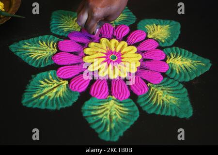 Une femme hindoue crée un motif ranglo coloré à l'aide de poudre colorée pendant le festival de Diwali à un temple hindou à Toronto, Ontario, Canada, on 04 novembre 2021. Le rangoli est un dessin traditionnel dessiné sur le sol avec de la poudre colorée, souvent devant les maisons ou les temples. (Photo de Creative Touch Imaging Ltd./NurPhoto) Banque D'Images