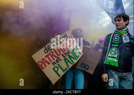 Une femme tient un écriteau contre le patriarcat et se cache presque par la fumée noire et jaune, lors d'une importante marche sur le climat organisée à Amsterdam, sur 6 novembre 2021. (Photo par Romy Arroyo Fernandez/NurPhoto) Banque D'Images