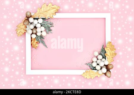 Fond de Noël enneigé sur rose avec cadre blanc, neige abstraite, décoration d'arbre boules à paillettes, acornes dorés, feuilles, sapin recouvert de neige. Banque D'Images