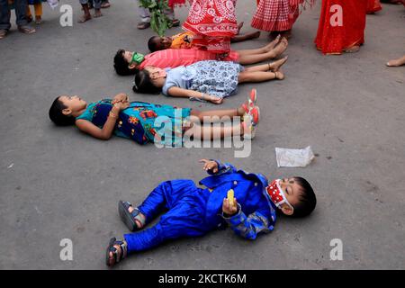 Les dévotés traversent les enfants qui se trouvent sur la route pendant le festival Chhata Puja. C'est un rituel pratiqué pour le bien-être des enfants à Kolkata sur 10 novembre,2021. La puja de Chhat implique l'adoration du Dieu du soleil. (Photo de Debajyoti Chakraborty/NurPhoto) Banque D'Images