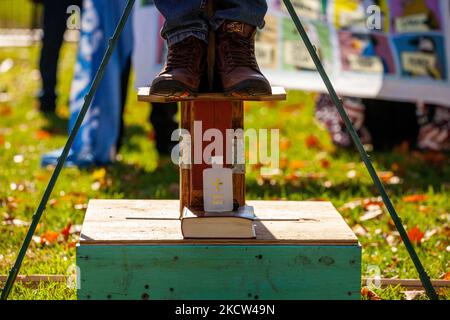 L'eau Sainte et une Bible sont assis sur la plate-forme sous les pieds de l'activiste de l'immigration Jose Landaverde alors qu'il est suspendu sur une croix en bois pendant une action directe de l'Alliance nationale TPS à la Maison Blanche. Les militants sont accrochés à des croix toute la journée pour symboliser le sacrifice que font les immigrants pour contribuer à la vie aux États-Unis par un travail long et dur. Les manifestants exigent que le Congrès, l'Administration Biden et le Parti démocrate terminent le traitement déshumanisant des immigrants en général, mais surtout à la frontière. (Photo d'Allison Bailey/NurPhoto) Banque D'Images