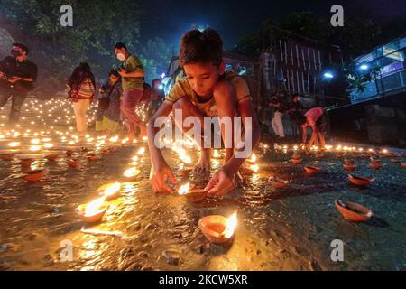 Un petit enfant est vu allumer des lampes à l'huile à un ghat de rivière à l'occasion de Dev Deepavali à Kolkata , Inde , le 19 novembre 2021 .Dev Deepavali est un festival hindou qui est célébré sur Karthik Purnima , 15 jours après Diwali et est considéré comme Diwali de Dieu . Les dévotés allument une lampe à huile sur les côtés du Gange pour rendre hommage à la rivière et à sa Déesse. (Photo par Debarchan Chatterjee/NurPhoto) Banque D'Images