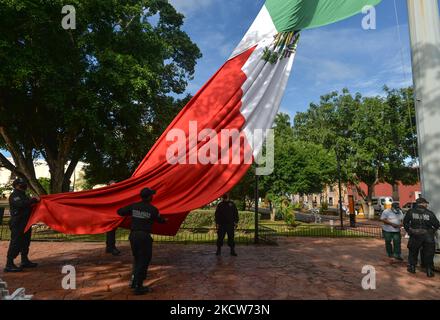 Les membres de la police municipale (Policía Municipal de Valladolid) replient le drapeau national du Mexique après la brève cérémonie d'El Día de la Revolucion (jour de la Révolution), fête nationale commémorant le début de la Révolution mexicaine sur 20 novembre 1910. Les célébrations officielles de la Révolution ont été annulées en raison de la pandémie de Covid-19. La ville de Valladolid a été le site de la « première étincelle de la Révolution mexicaine », également connue sous le nom de Plan Dzelkoop, un soulèvement qui a commencé sur 4 juin 1910, par Maximiliano R. Bonilla et d'autres dirigeants du Centre électoral indépendant et de l'anti Banque D'Images