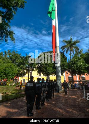 Des membres de la police municipale (Policía Municipal de Valladolid) devant le grand drapeau national du Mexique lors de la brève cérémonie d'El Día de la Revolucion (jour de la Révolution), fête nationale commémorant le début de la Révolution mexicaine sur 20 novembre 1910. Les célébrations officielles de la Révolution ont été annulées en raison de la pandémie de Covid-19. La ville de Valladolid a été le site de la « première étincelle de la Révolution mexicaine », également connue sous le nom de Plan Dzelkoop, un soulèvement qui a commencé sur 4 juin 1910, par Maximiliano R. Bonilla et d'autres dirigeants du Centre électoral indépendant Banque D'Images