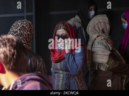 Masoumeh Ataei (C), victime d'une attaque acide, parle sur son smartphone dans une salle de théâtre après avoir joué dans une pièce au Forum de théâtre dans le centre-ville de Téhéran, 21 novembre 2021. Masoumeh a perdu sa vue et son visage dans une attaque acide il y a dix ans, et maintenant elle fait de son mieux pour collecter 70 000 GBP pour les frais de chirurgie en Grande-Bretagne pour retrouver sa vue. (Photo de Morteza Nikoubazl/NurPhoto) Banque D'Images