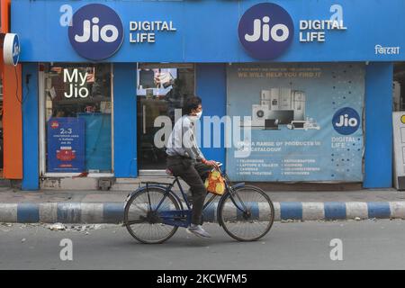 Un homme portant un masque passe devant un magasin Reliance Jio à Kolkata , en Inde , le 24 novembre 2021 . Selon les données TRAI , Reliance Jio perd plus de 19 millions d'utilisateurs mobiles en septembre. (Photo par Debarchan Chatterjee/NurPhoto) Banque D'Images