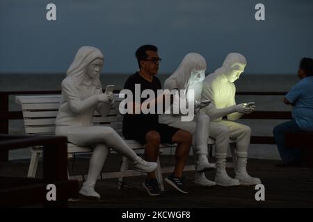 Les gens prennent des photos devant l'installation de la sculpture « absorbée par la lumière » conçue par le Gala britannique May Lucas et réalisée par le sculpteur berlinois Karoline Hinz, à Progreso. Mardi, 23 novembre 2021, à Progreso, Yucatan, Mexique. (Photo par Artur Widak/NurPhoto) Banque D'Images