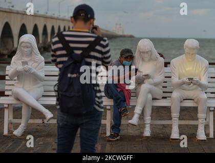 Les gens prennent des photos devant l'installation de la sculpture « absorbée par la lumière » conçue par le Gala britannique May Lucas et réalisée par le sculpteur berlinois Karoline Hinz, à Progreso. Mardi, 23 novembre 2021, à Progreso, Yucatan, Mexique. (Photo par Artur Widak/NurPhoto) Banque D'Images