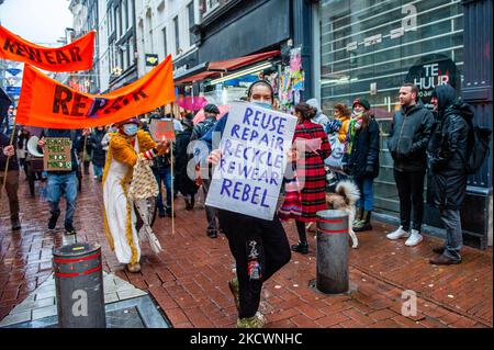 Un groupe d'activistes de la rébellion d'extinction marche le long de la rue commerçante la plus achalandée, tout en tenant des banderoles contre le Vendredi fou et la mode rapide, lors d'un défilé de mode organisé par XR, contre le Vendredi fou à Amsterdam, sur 27 novembre 2021. (Photo par Romy Arroyo Fernandez/NurPhoto) Banque D'Images