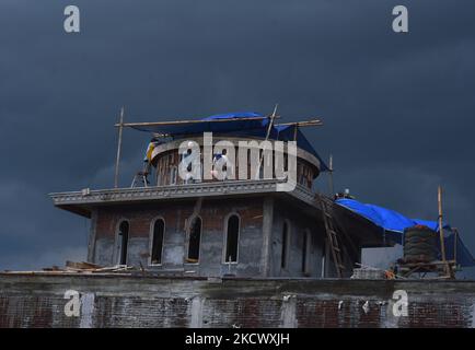 Certains travailleurs occasionnels (travailleurs de la construction) construisent un dôme de mosquée dans le village de Tanjungrejo, Malang, est de Java, sur 29 novembre 2021. Le ministère indonésien de la main-d'oeuvre encourage les travailleurs informels à s'inscrire à l'assurance-emploi du BPJS à des tarifs abordables. Afin qu'ils bénéficient d'une protection sociale sous la forme d'une assurance accident du travail (JKK). (Photo par Aman Rochman/NurPhoto) Banque D'Images