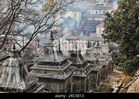 Fumée provenant d'un corps incinéré, vue parmi les nombreuses chayas et autres bâtiments du complexe du temple hindou de Pashupatinath, au Népal. En arrière-plan, la fumée s'élève des ghats de crémation, car un corps est incinéré par la rive de la rivière Bagmati. Le complexe de Pashupatinath est le plus sacré site hindou du Népal. (Photo de Creative Touch Imaging Ltd./NurPhoto) Banque D'Images