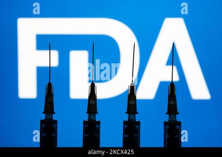 Les seringues médicales et le logo de la FDA affichés en arrière-plan sont illustrés sur cette photo prise à Cracovie, en Pologne, sur 2 décembre 2021. (Photo de Jakub Porzycki/NurPhoto) Banque D'Images