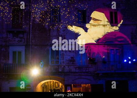 Piazza Duomo et les bâtiments environnants illuminés par les projections des lumières de Noël sur Piazza Duomo à Bisceglie le 2 décembre 2021. L'Association Borgo Antico, pour annoncer le calendrier des événements dans le centre historique de Bisceglie pour les prochaines vacances, a invité tous les citoyens à découvrir ensemble une surprise magique qui a officiellement lancé les initiatives de Noël de cette année. Sur la Piazza Duomo, il a donné aux adultes et aux enfants un spectacle qui a transformé le visage de la cathédrale et des bâtiments qui l'entourent en un lieu de rêve avec les projections passionnantes des lumières de Noël. (Photo Banque D'Images