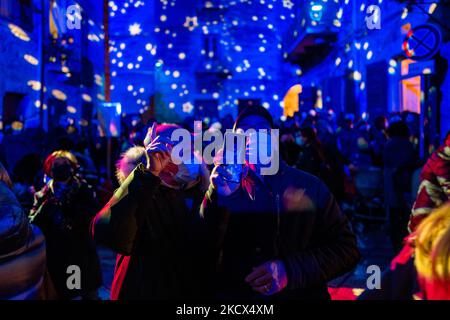 Personnes photographiant la Piazza Duomo avec leurs smartphones et les bâtiments environnants illuminés par les projections des lumières de Noël sur la Piazza Duomo à Bisceglie le 2 décembre 2021. L'Association Borgo Antico, pour annoncer le calendrier des événements dans le centre historique de Bisceglie pour les prochaines vacances, a invité tous les citoyens à découvrir ensemble une surprise magique qui a officiellement lancé les initiatives de Noël de cette année. Sur la Piazza Duomo, il a donné aux adultes et aux enfants un spectacle qui a transformé la face de la cathédrale et les bâtiments qui l'entourent en un lieu de rêve avec l'excelle Banque D'Images
