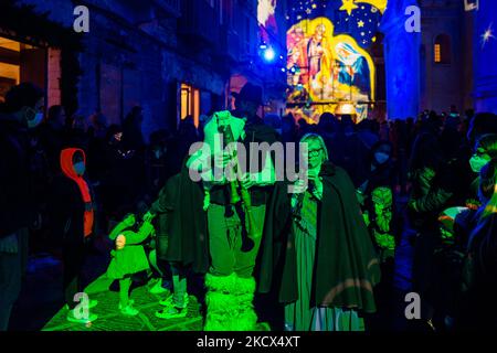 Les gens écoutent la musique populaire de deux cornemuses avec la Piazza Duomo et les bâtiments environnants illuminés par les projections des lumières de Noël sur la Piazza Duomo à Bisceglie le 2 décembre 2021. L'Association Borgo Antico, pour annoncer le calendrier des événements dans le centre historique de Bisceglie pour les prochaines vacances, a invité tous les citoyens à découvrir ensemble une surprise magique qui a officiellement lancé les initiatives de Noël de cette année. Sur la Piazza Duomo, il a donné aux adultes et aux enfants un spectacle qui a transformé la face de la cathédrale et les bâtiments qui l'entourent en un plac de rêve Banque D'Images