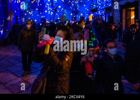 Personnes photographiant la Piazza Duomo avec leurs smartphones et les bâtiments environnants illuminés par les projections des lumières de Noël sur la Piazza Duomo à Bisceglie le 2 décembre 2021. L'Association Borgo Antico, pour annoncer le calendrier des événements dans le centre historique de Bisceglie pour les prochaines vacances, a invité tous les citoyens à découvrir ensemble une surprise magique qui a officiellement lancé les initiatives de Noël de cette année. Sur la Piazza Duomo, il a donné aux adultes et aux enfants un spectacle qui a transformé la face de la cathédrale et les bâtiments qui l'entourent en un lieu de rêve avec l'excelle Banque D'Images